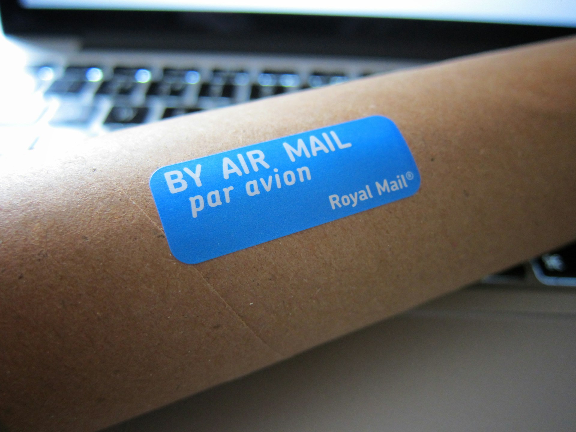 Package roll on a laptop with a blue Royal Mail stamp.
